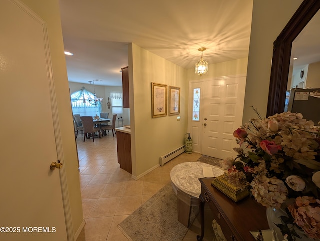 entryway with light tile patterned floors, baseboard heating, baseboards, and a notable chandelier