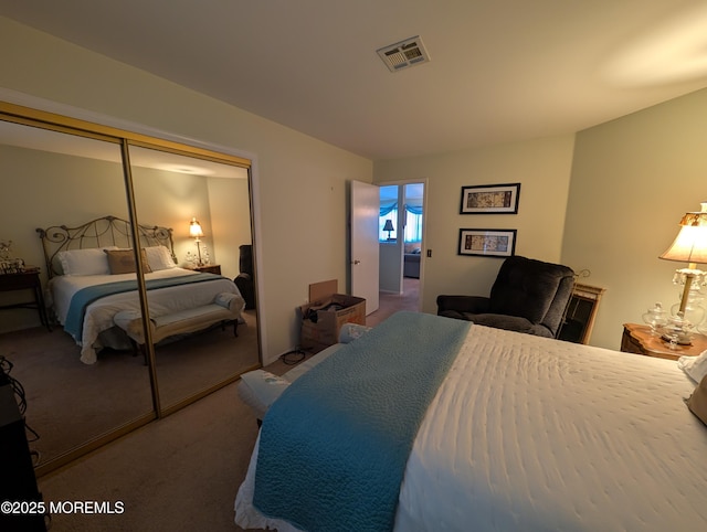 carpeted bedroom with a closet and visible vents