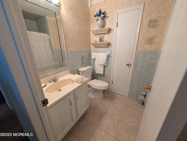 bathroom featuring wallpapered walls, vanity, and wainscoting