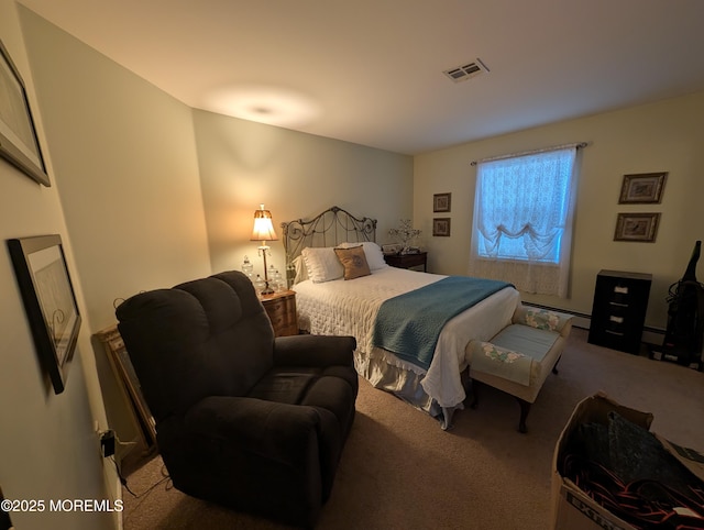 bedroom with a baseboard heating unit, carpet, and visible vents