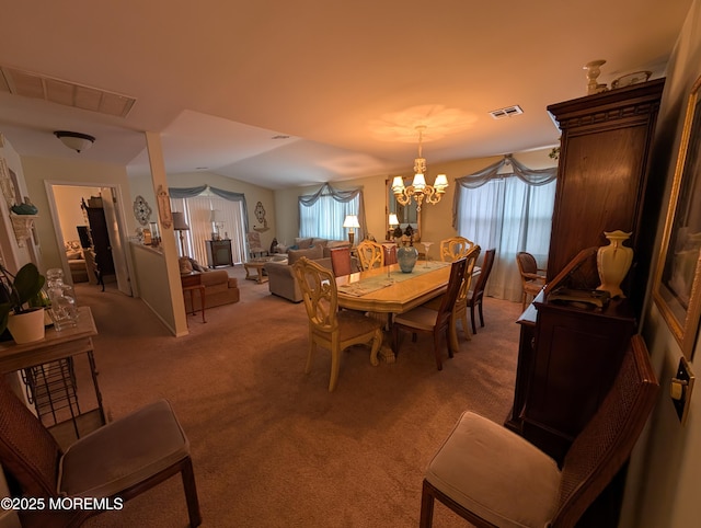 dining area featuring an inviting chandelier, visible vents, vaulted ceiling, and light colored carpet