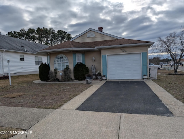 view of front of home featuring driveway, a shingled roof, a chimney, and an attached garage