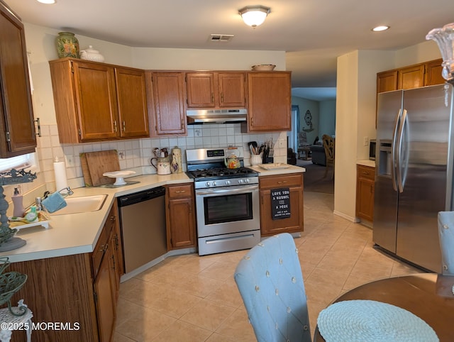 kitchen featuring light tile patterned floors, under cabinet range hood, visible vents, light countertops, and appliances with stainless steel finishes