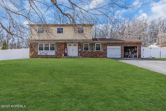 view of front of house with aphalt driveway, a front yard, a gate, fence, and a garage