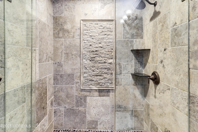 interior details featuring tiled shower