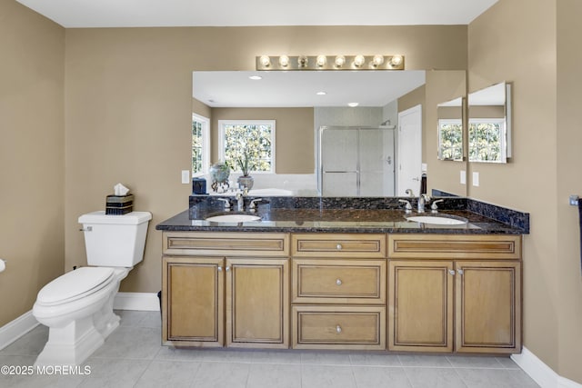 bathroom featuring tile patterned flooring, a sink, toilet, and a shower stall