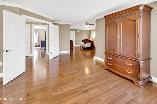 corridor featuring ornamental molding, light wood-style floors, and baseboards