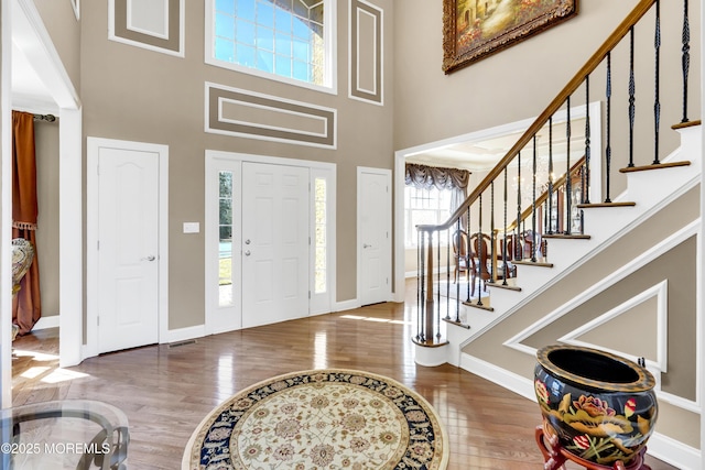 entrance foyer with a high ceiling, baseboards, and wood finished floors