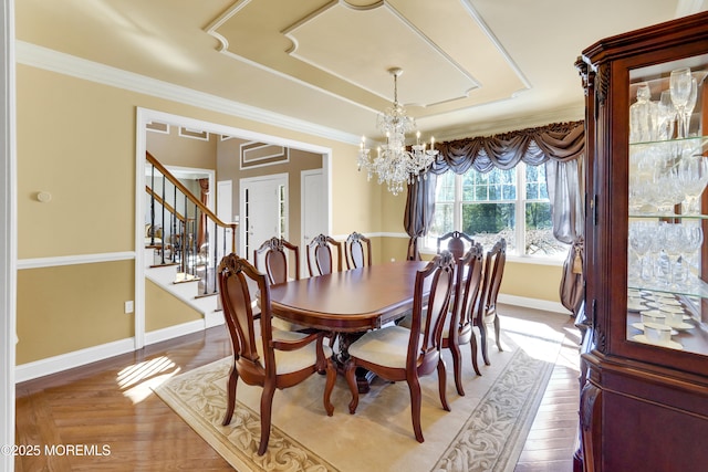 dining space featuring baseboards, stairway, light wood finished floors, an inviting chandelier, and crown molding