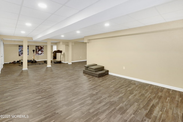 workout area featuring a paneled ceiling, recessed lighting, baseboards, and wood finished floors