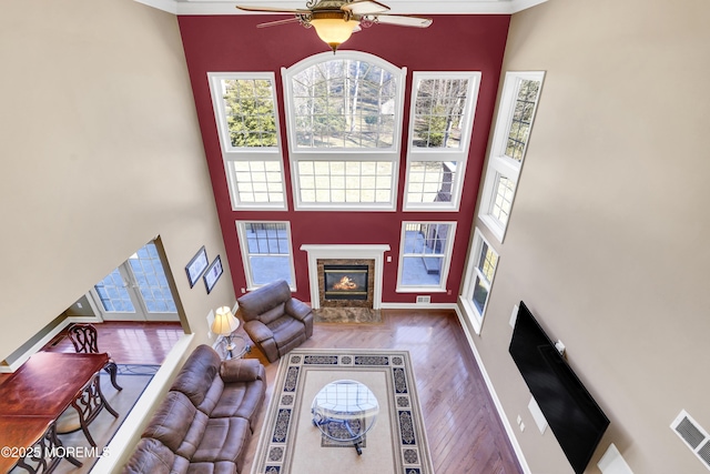 living area featuring visible vents, a premium fireplace, wood finished floors, and a wealth of natural light