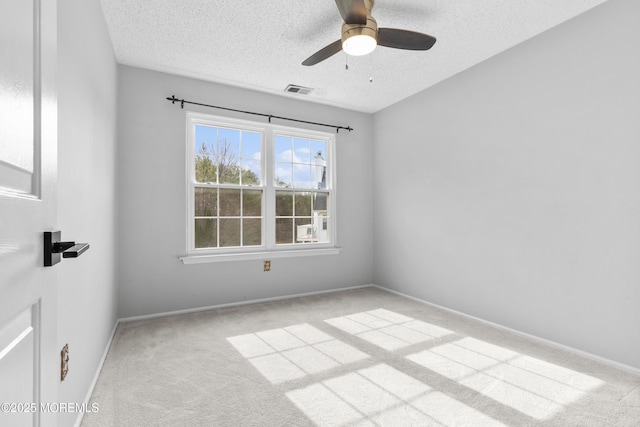 unfurnished room with a textured ceiling, a ceiling fan, visible vents, baseboards, and carpet