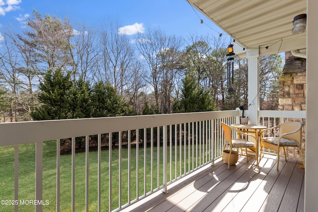 wooden terrace featuring a lawn