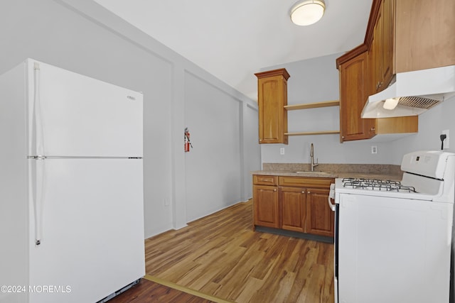 kitchen with white appliances, light wood-type flooring, under cabinet range hood, open shelves, and a sink