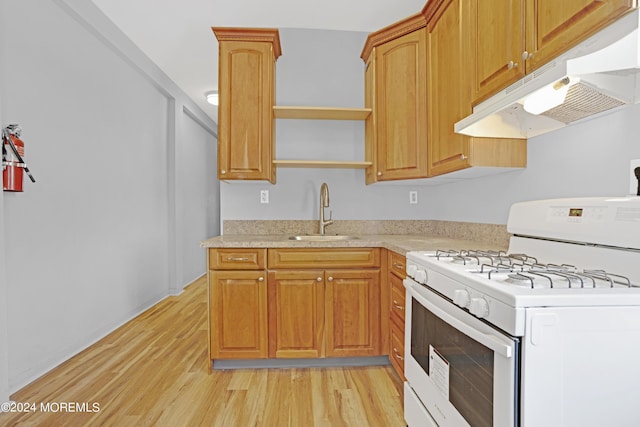 kitchen featuring open shelves, light wood-style floors, a sink, under cabinet range hood, and white gas range oven