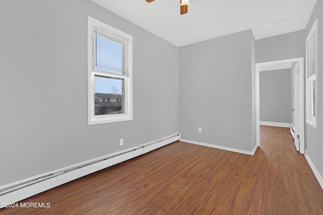 unfurnished bedroom with a baseboard heating unit, ceiling fan, wood finished floors, and baseboards