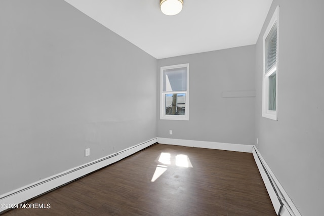 empty room with a baseboard heating unit, baseboard heating, dark wood finished floors, and baseboards