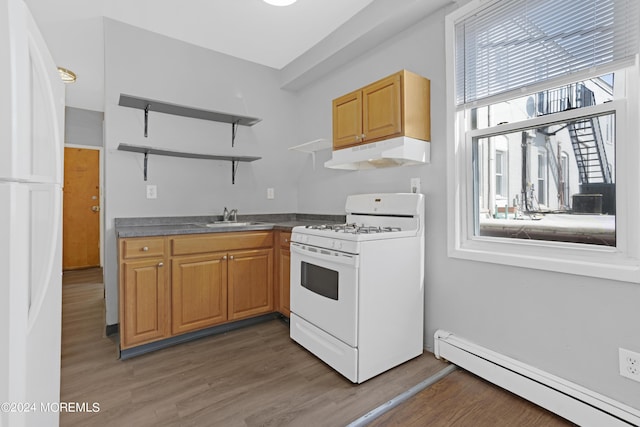 kitchen featuring a baseboard radiator, under cabinet range hood, white appliances, a sink, and open shelves