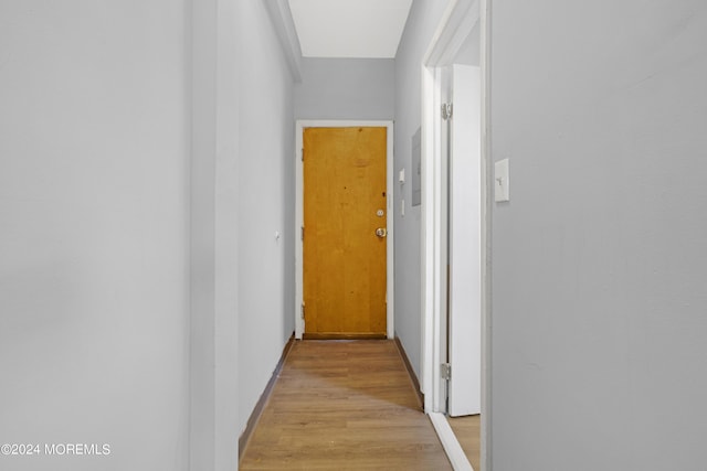 hall with light wood-type flooring and baseboards