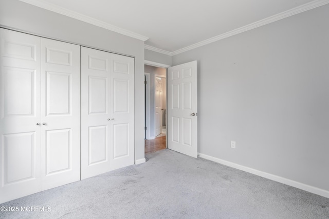 unfurnished bedroom with crown molding, carpet floors, a closet, and baseboards