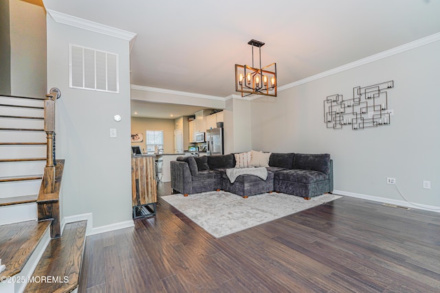 living area featuring crown molding, visible vents, dark wood finished floors, and stairs