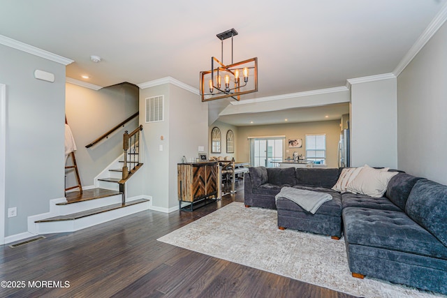 living area with stairs, visible vents, wood finished floors, and ornamental molding