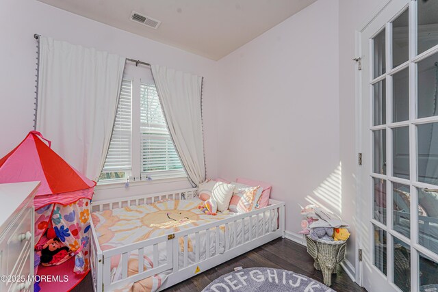 bedroom with visible vents and wood finished floors