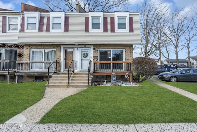 multi unit property with a front lawn and brick siding