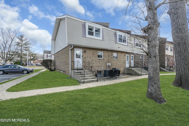 exterior space with brick siding, central AC unit, and a lawn