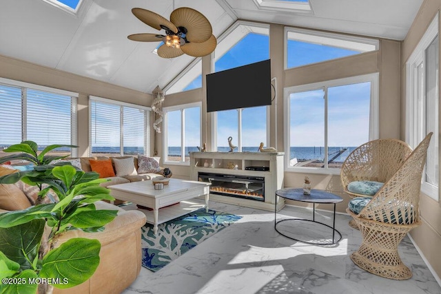 sunroom / solarium featuring vaulted ceiling, a glass covered fireplace, and a ceiling fan