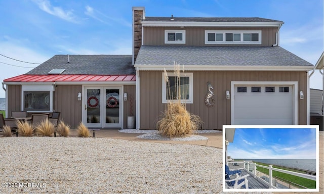 view of front of house with french doors, roof with shingles, a chimney, a standing seam roof, and metal roof