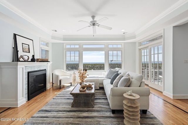 living area with light wood-type flooring, a fireplace, and crown molding