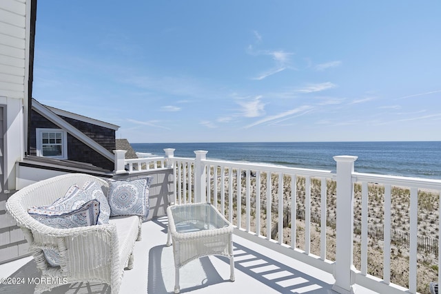 balcony featuring a water view and a view of the beach