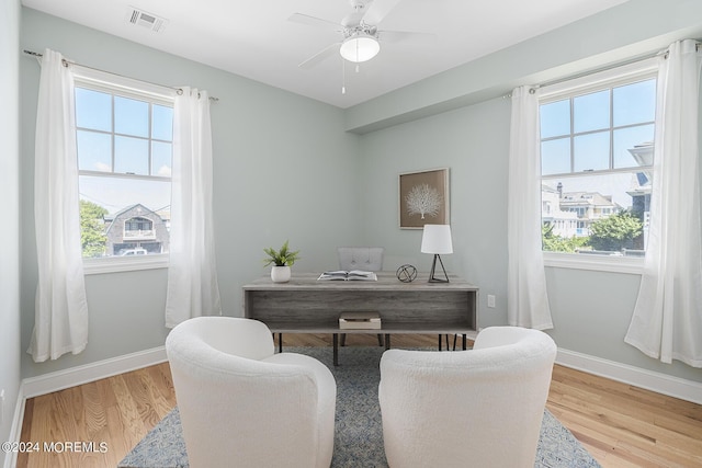 home office with a wealth of natural light, baseboards, and wood finished floors