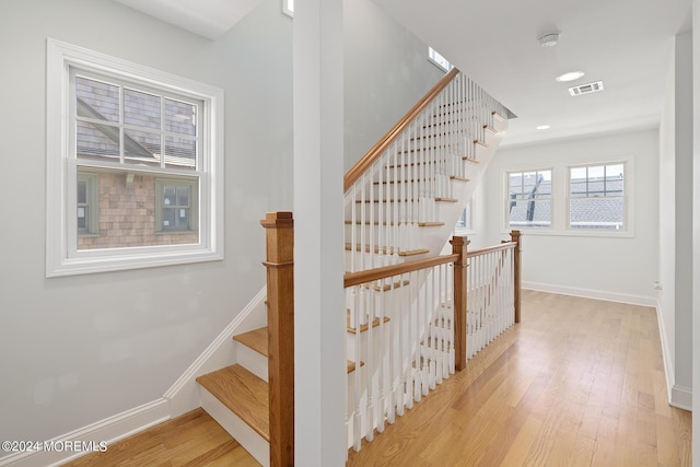 stairway with recessed lighting, wood finished floors, visible vents, and baseboards