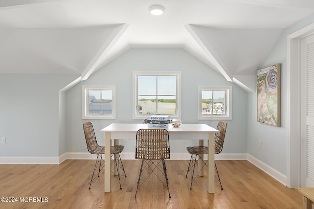 dining space featuring vaulted ceiling, light wood-type flooring, and baseboards