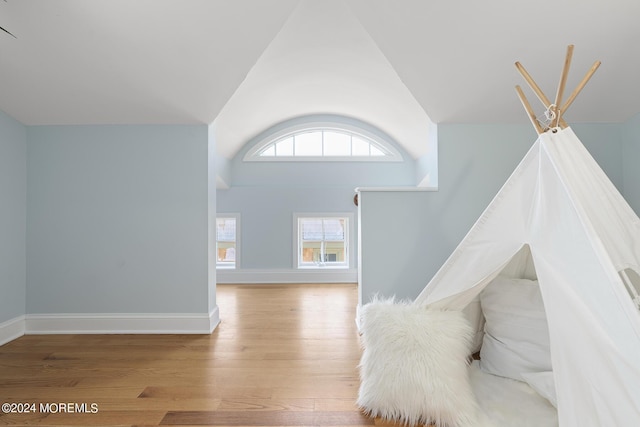 interior space featuring high vaulted ceiling, baseboards, and wood finished floors