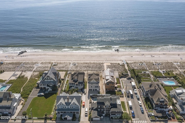 birds eye view of property with a water view and a view of the beach