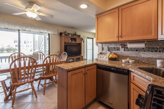 kitchen featuring a peninsula, light tile patterned flooring, gas range oven, dishwasher, and tasteful backsplash