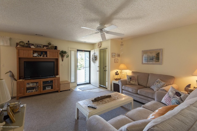 living room featuring visible vents, a textured ceiling, a ceiling fan, and carpet