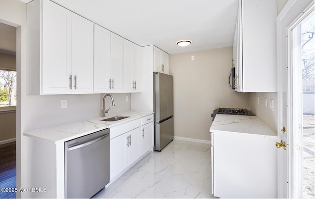 kitchen featuring stainless steel appliances, plenty of natural light, marble finish floor, and a sink