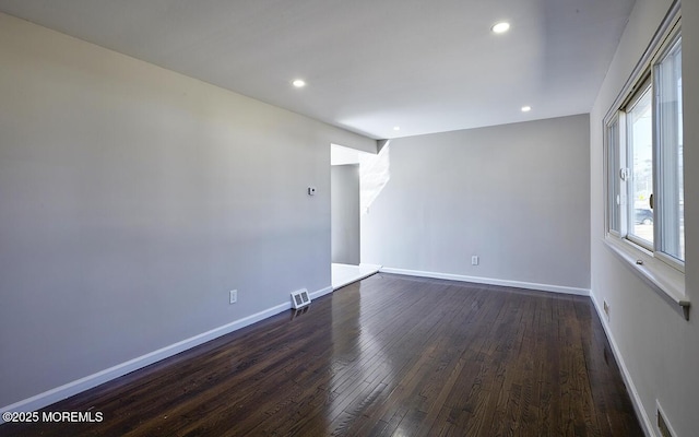 unfurnished room featuring dark wood-type flooring, recessed lighting, visible vents, and baseboards