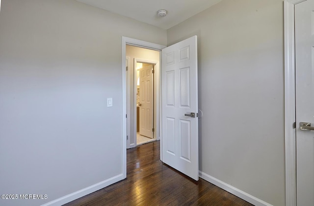 unfurnished bedroom with dark wood-style floors and baseboards