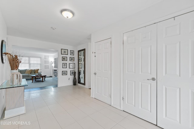 foyer entrance featuring light tile patterned floors and a fireplace