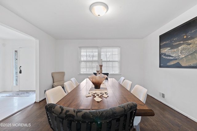 dining space featuring visible vents, baseboards, and wood finished floors