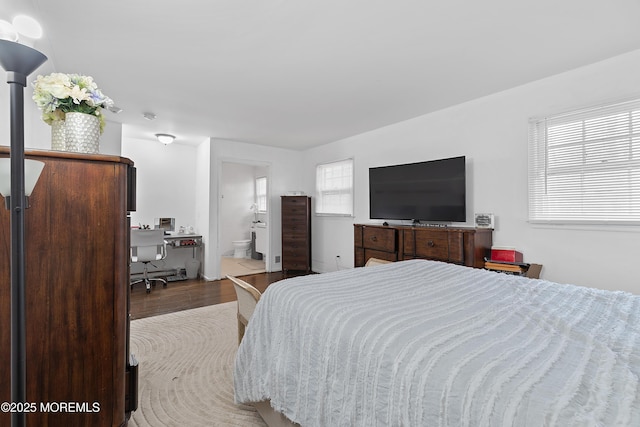 bedroom featuring connected bathroom and wood finished floors