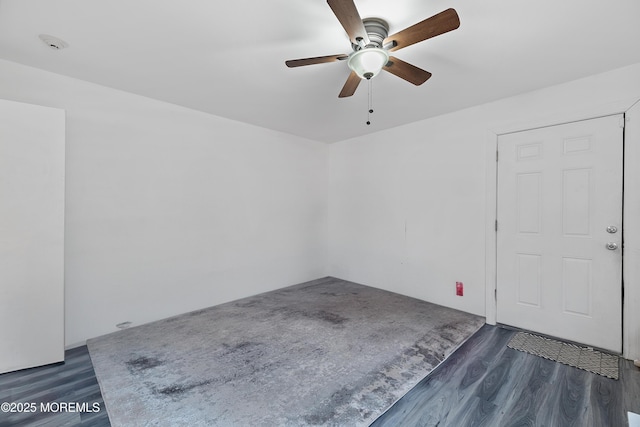 empty room featuring ceiling fan and dark wood-type flooring