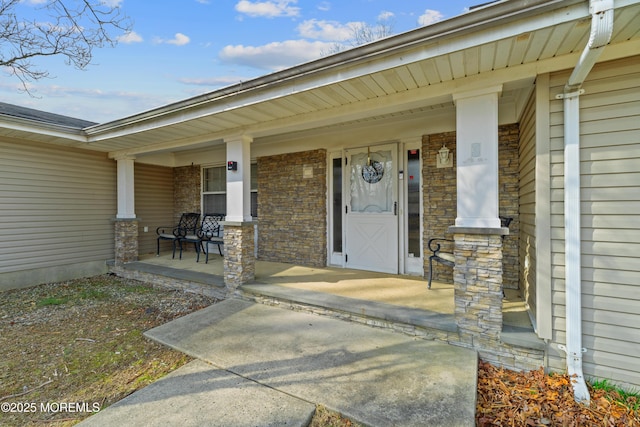 entrance to property featuring covered porch and stone siding