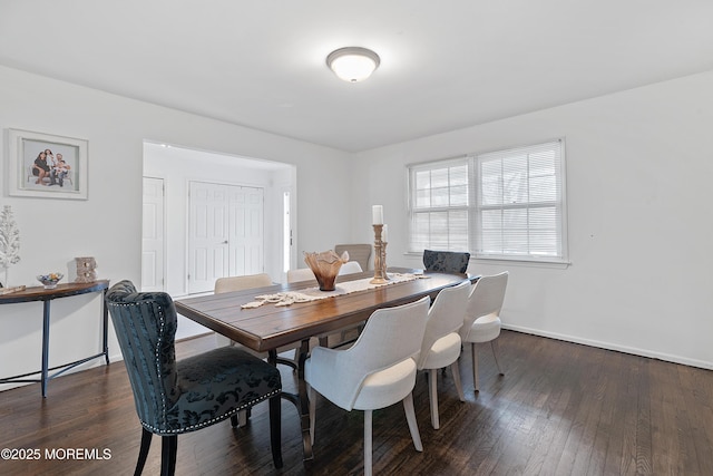 dining space with wood-type flooring and baseboards