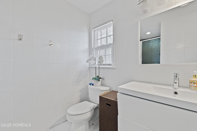 full bathroom with toilet, tile walls, and vanity